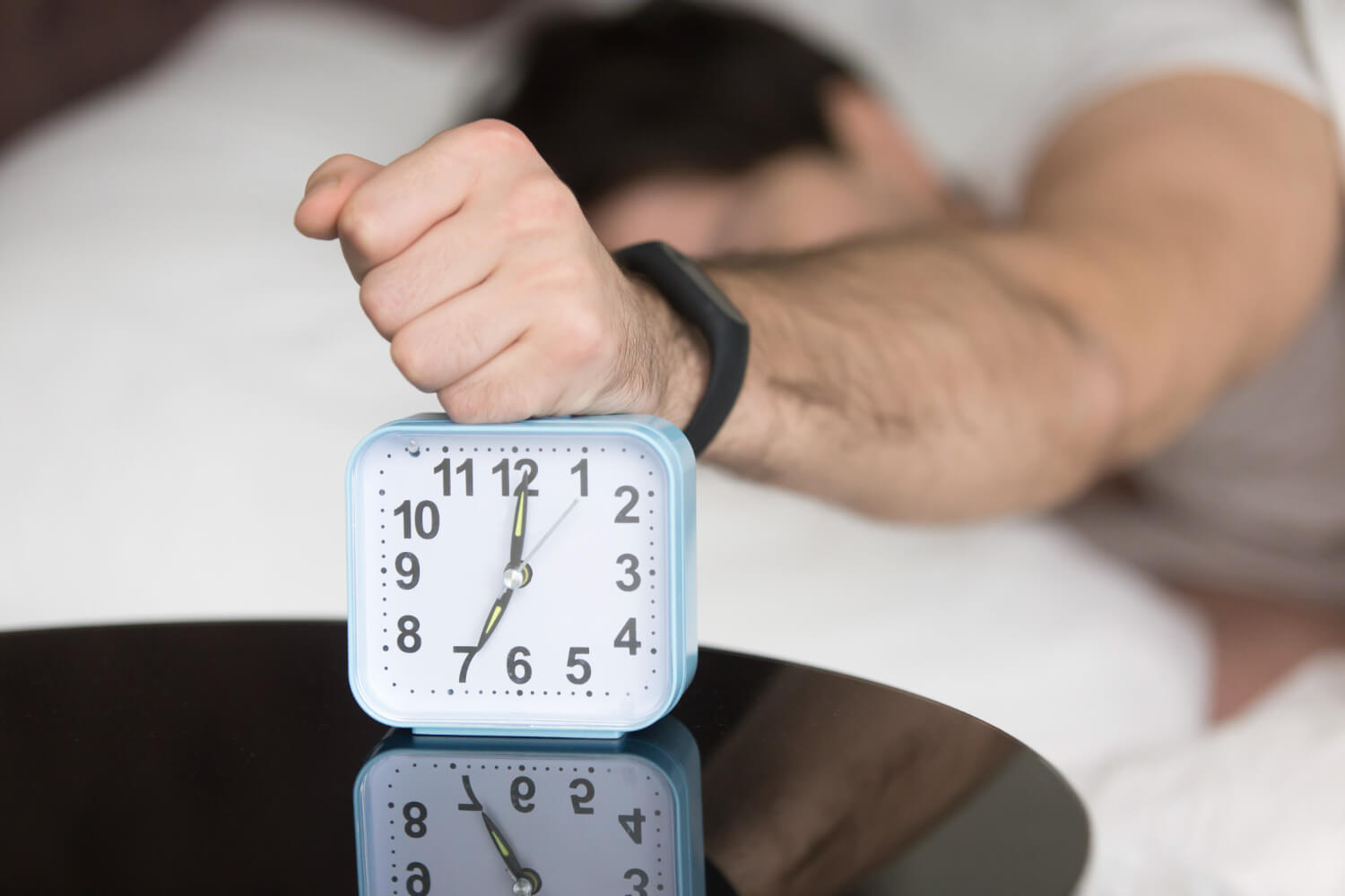 angry sleepy young guy turning off noisy annoying alarm clock 1 zweten in je slaap