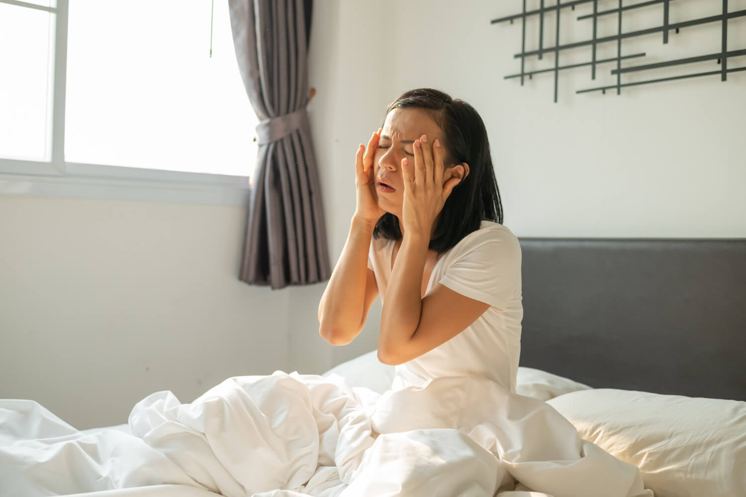 hangover girl sleeps with headache unhappy woman feeling headache after sudden awakening by phone call alarm early morning exhausted young female suffering from insomnia migraine lying bed 1 zweten in je slaap - vrouw vermoeid